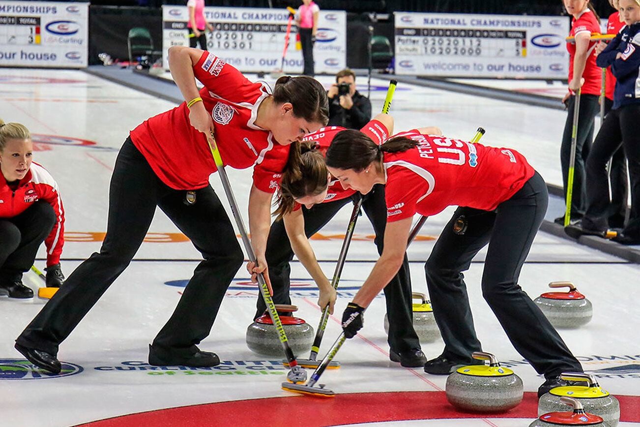foto de 3 atletas de uma equipe de curling, em ação com suas vassourinhas