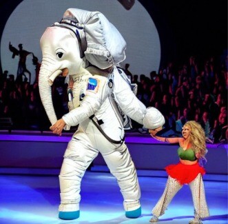 Imagem gerada por “inteligência artificial“ a partir do meu prompt: 'shakira dancing with an elephant dressed as an astronaut, as seen from the audience'