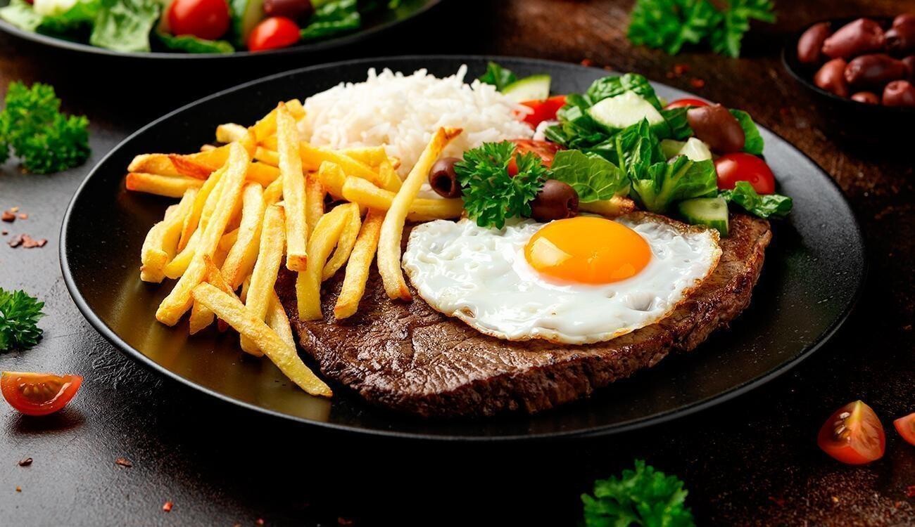foto de um bife a cavalo, com fritas palito, arroz branco e salada fresca