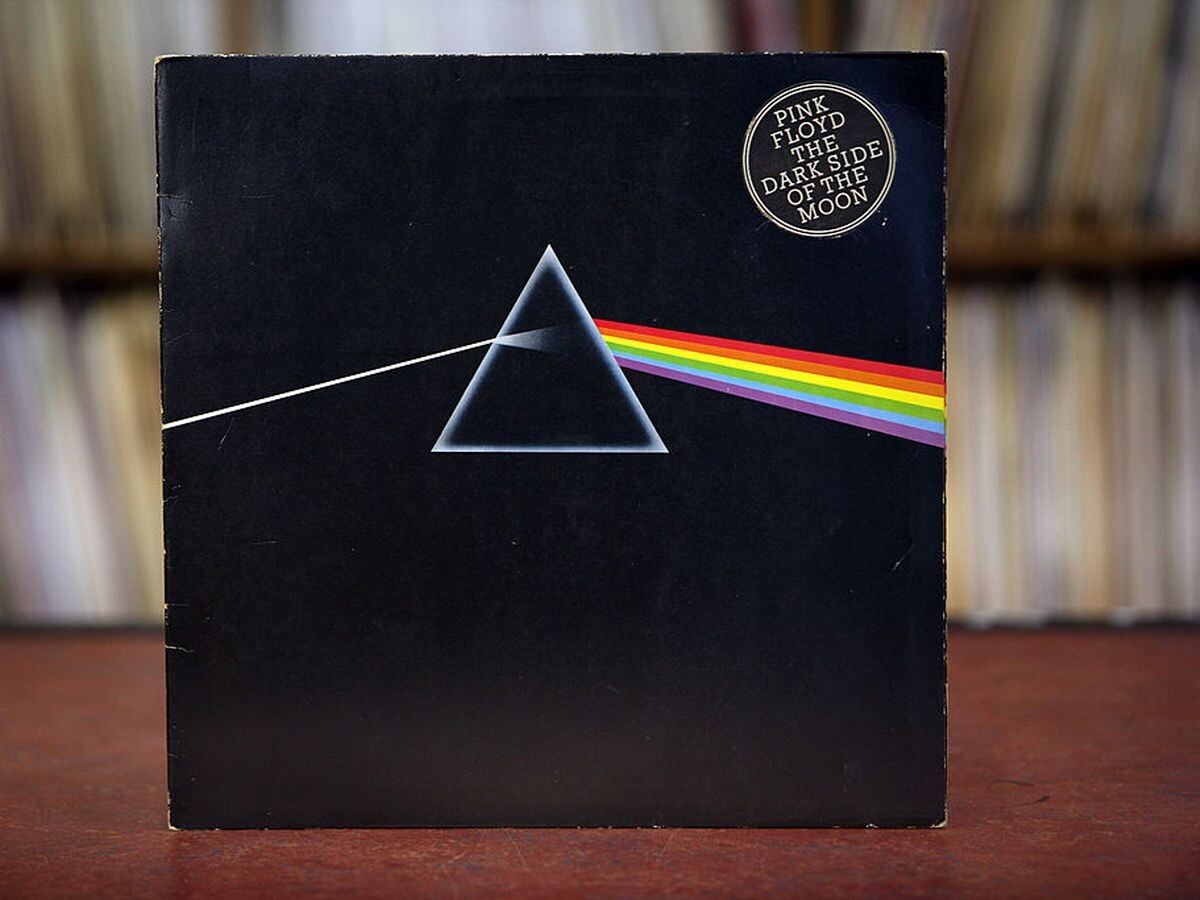 Capa do LP The Dark Side of th Moon, com um feixe de luz branca sendo decomposto nas 7 cores do arco íris por um prisma.