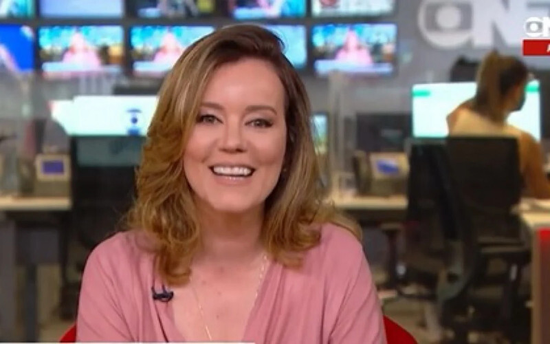 Foto da aniversariante Natuza Nery apresentando um telejornal e sorrindo