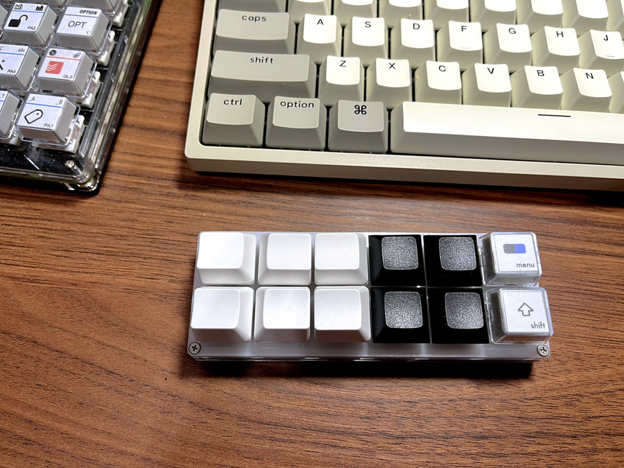 um teclado programável com 6 teclas brancas, 4 teclas pretas, e 2 teclas com rótulos