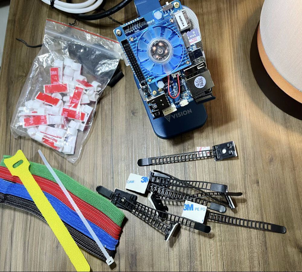 Uma placa Odroid cercada por acessórios de organização e fixação de cabos