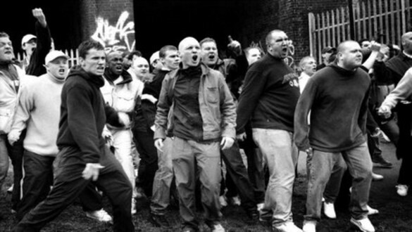 Foto em preto e branco de um bando de hooligans em atitude violenta