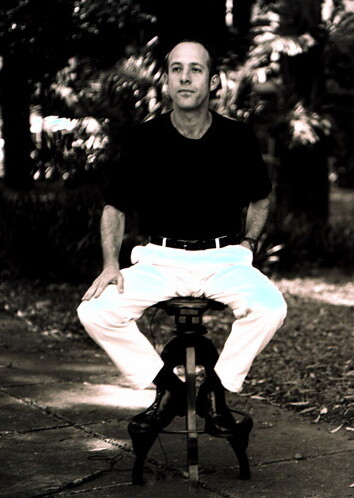 Foto em preto e branco de Marcelo Fromer, sozinho em meio a um jardim