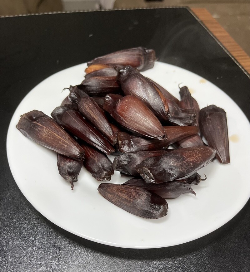 19 pinhões em um prato branco, com o vapor saindo, porque estão bem quentes