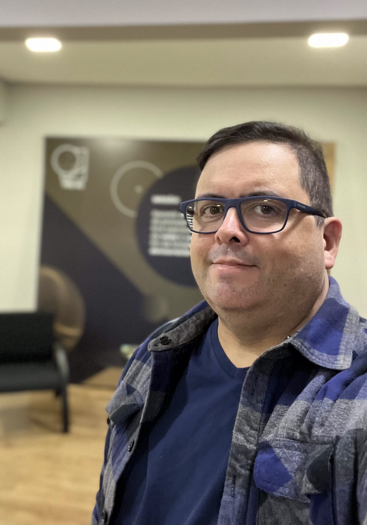 Selfie minha, de blusa de flanela azul, camiseta azul e óculos de armação azul