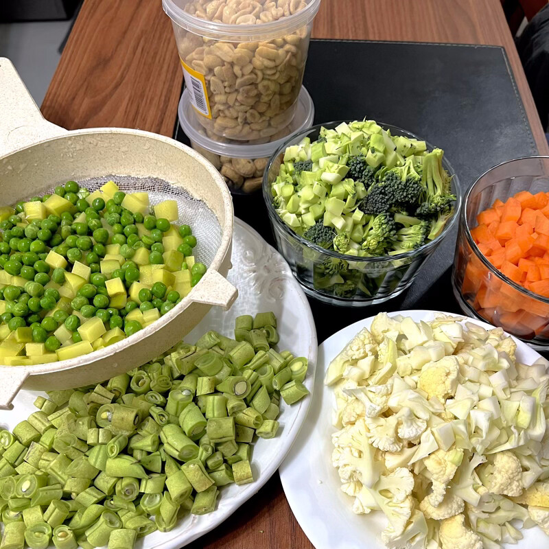 De baixo pra cima: vagem picada, couve-flor picada, batata+ervilha (os unicos que serão fervidos antes de guardar), brócolis picado, cenoura picada, amendoim e castanha de cajüt