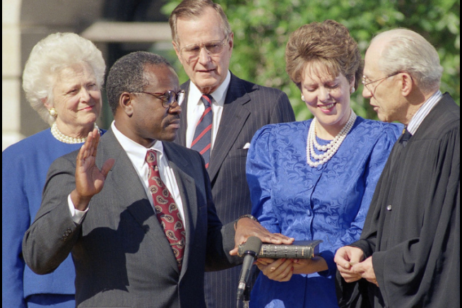 Clarence Thomas presta seu compromisso, na presença de quem o alçou