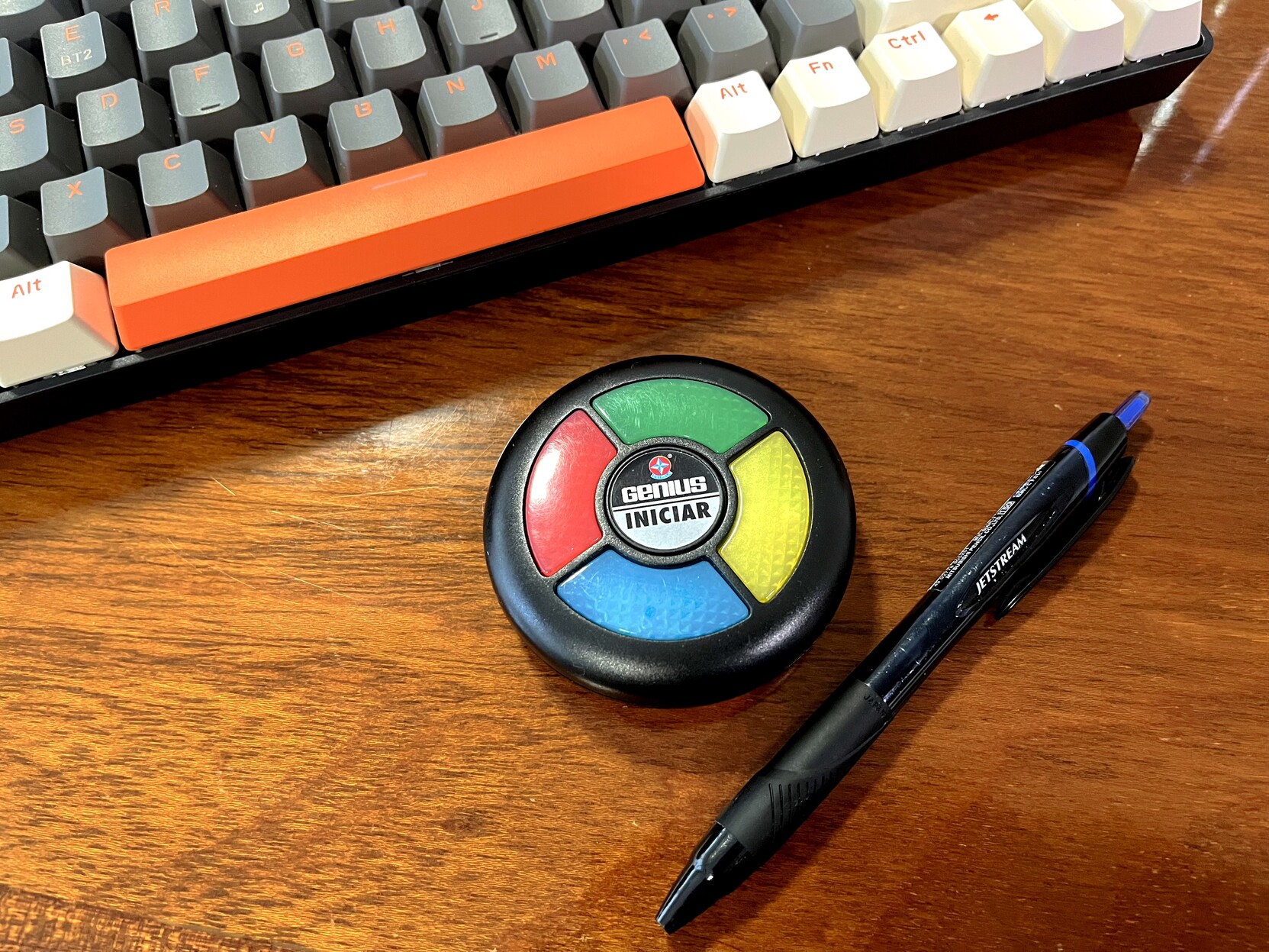 Um jogo Genius da Estrela, em formato reduzido, com uma caneta e um teclado para a escala