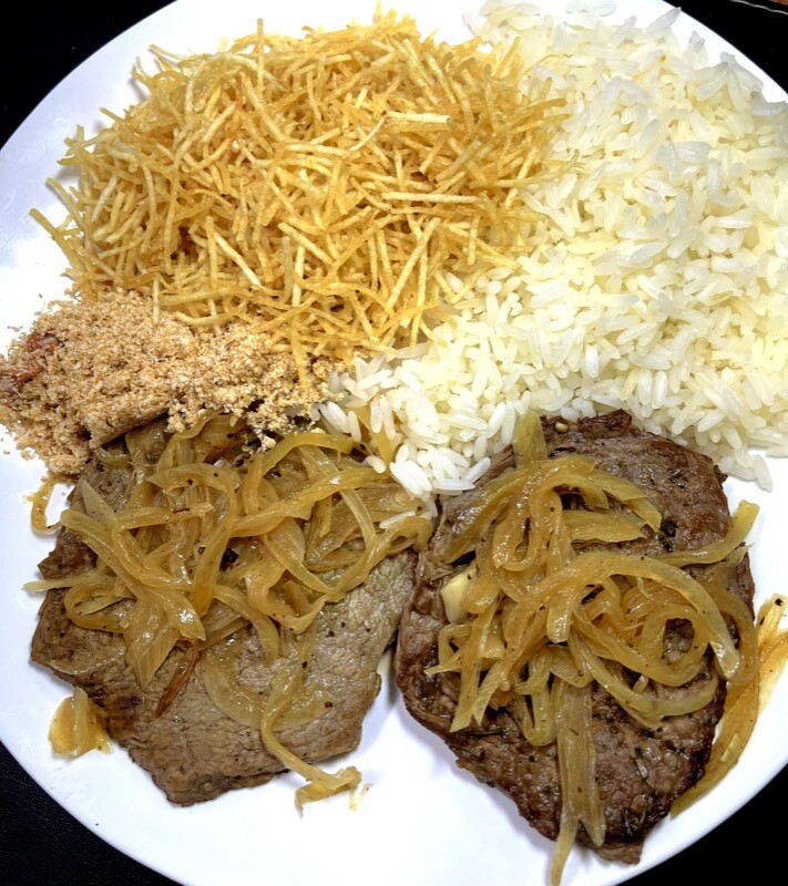 prato servido com 2 bifes acebolados, arroz branco, farofa e batata palha