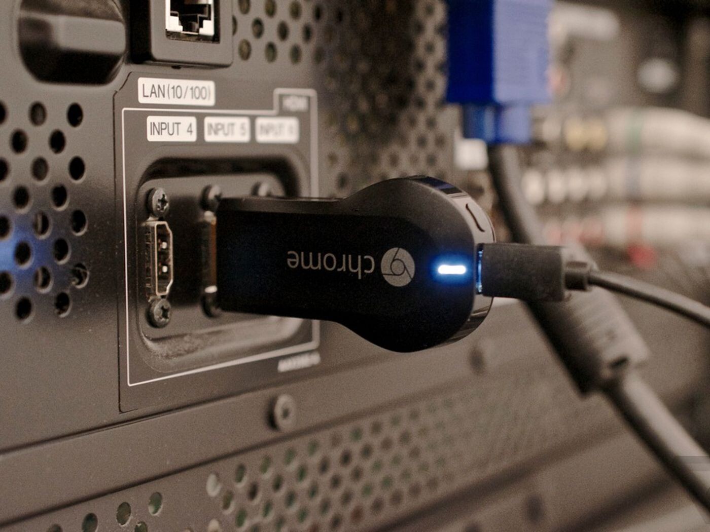 Um ChromeCast conectado à porta HDMI e com o cabo USB de alimentação plugado