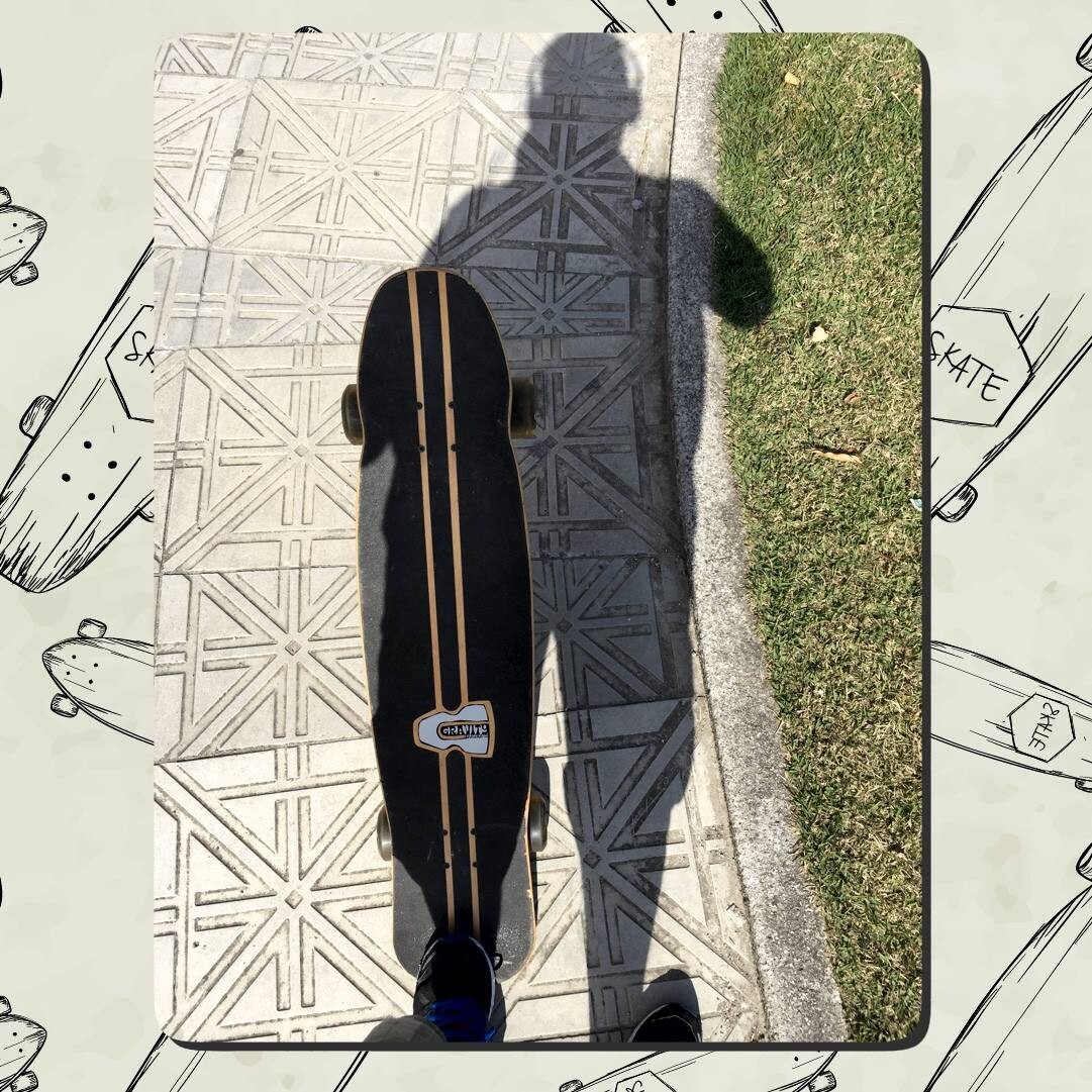 Meu pé sobre um skate longboard na calçada, e minha sombra formando uma silhueta com fones de ouvido