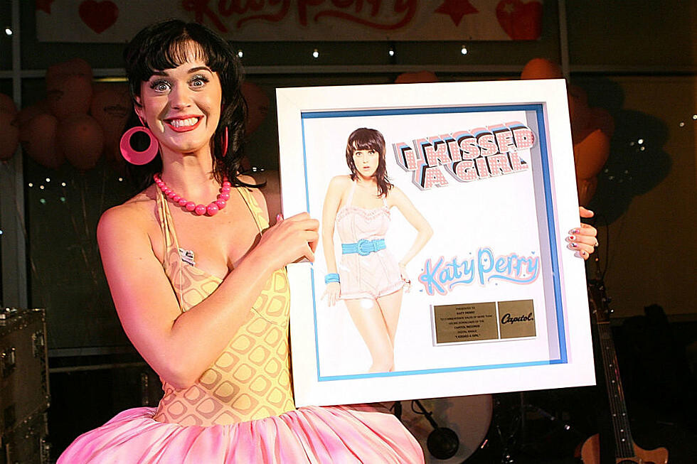 Katy Perry sorri segurando certificado de vendagem do single de I Kissed a Girl