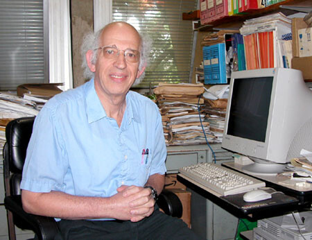 O grande Imre Simon sorri para a câmera, em frente a um PC