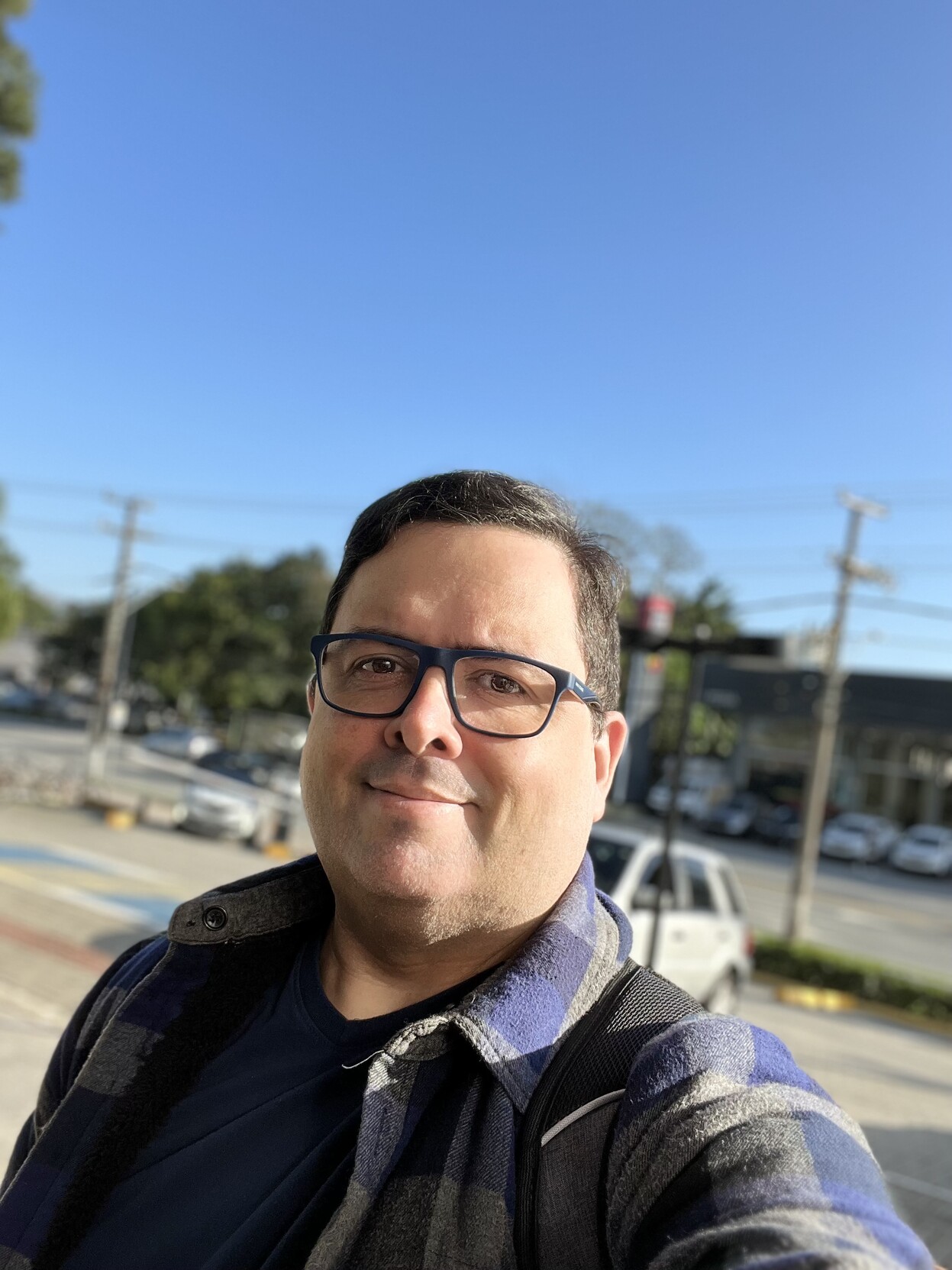 Selfie minha, de camiseta azul, blusa grunge azul, óculos de armação azul, na calçada e sob o céu azul