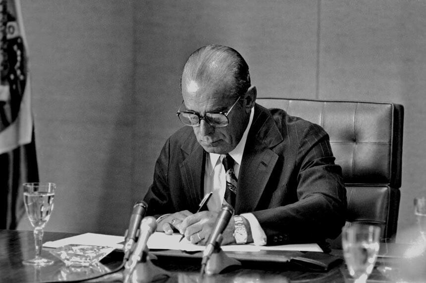 João Figueiredo assina documento em sua mesa