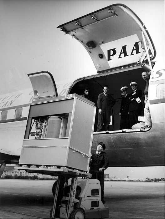 Tripulação observa enquanto empilhadeira embarca um IBM 350 Disk Storage Unit Model 1 para ser transportado via aérea<br>