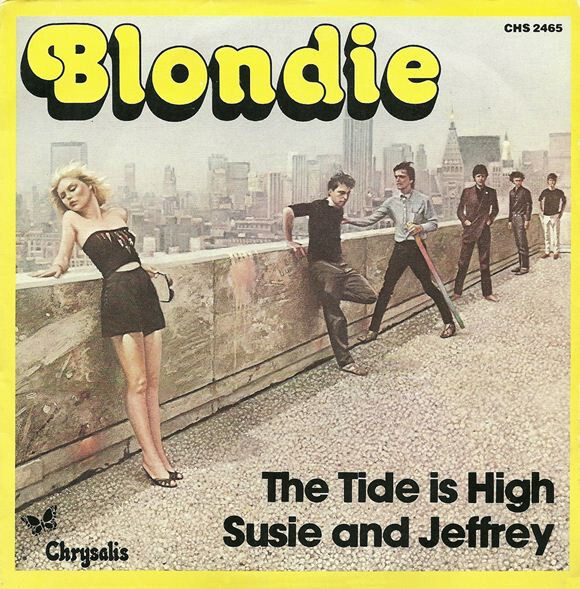 Capa do single de The Tide is High, com a banda perfilada junto a um parapeito, e cenário urbano ao fundo