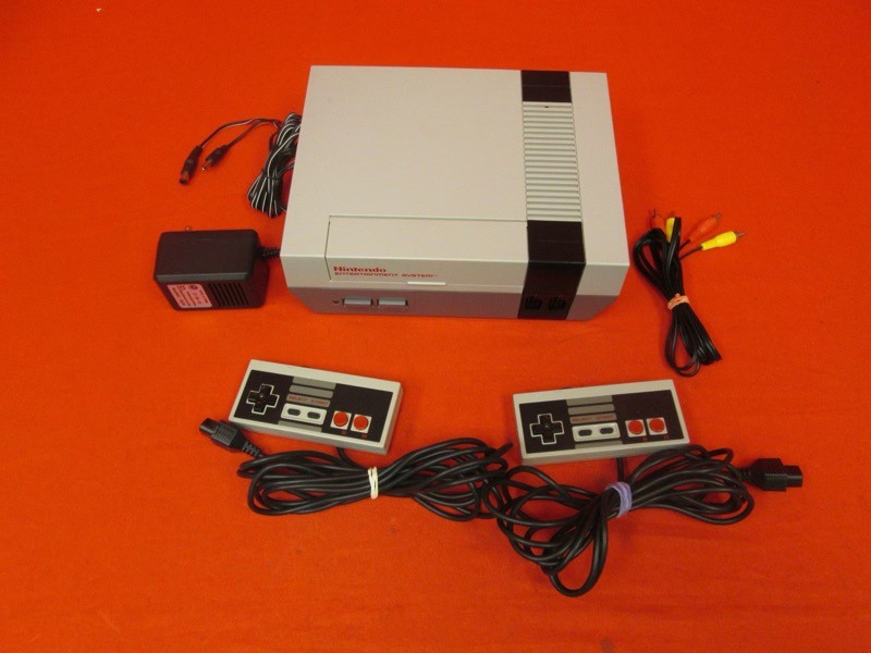 Um NES com 2 controles, fonte de alimentação e cabo de áudio e vídeo