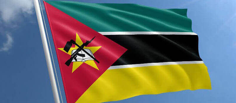 Bandeira de Moçambique, cujo emblema é um rifle AK-47 cruzado com uma enxada, ambos sobrepostos a um livro aberto.