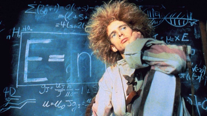 Cena de Young Einstein, de 1988, com o protagonista em frente a um quadro em que está anotada a fórmula célebre