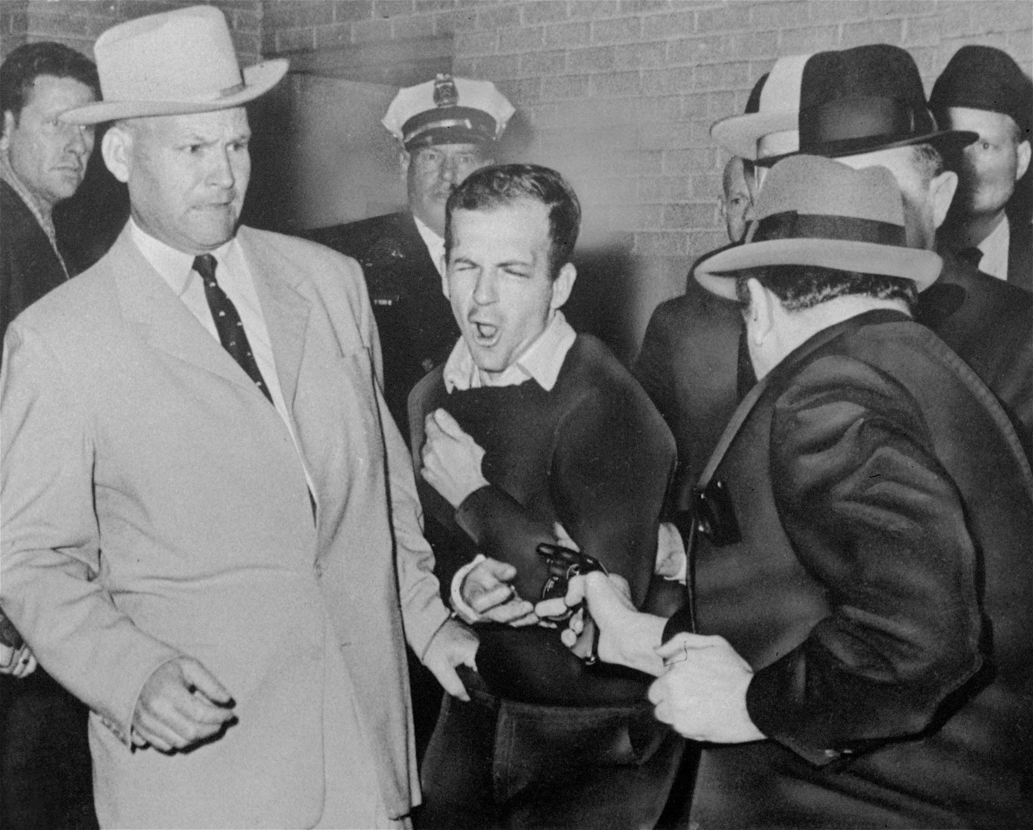O momento do tiro, com Oswald de frente para a câmera, e Ruby de costas