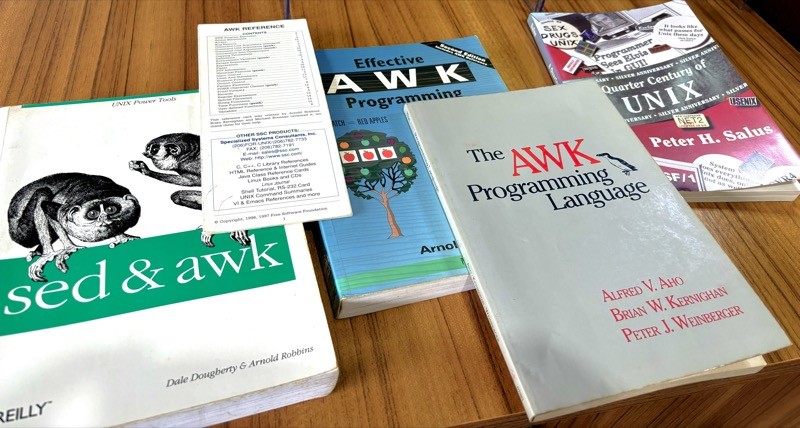 3 books on the AWK programming language and one on the history of Unix, side by side on my table.