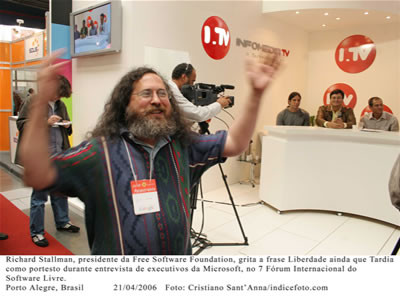 Foto publicada pelo evento na data dos acontecimentos, com a legenda: Richard Stallman, presidente da Free Software Foundation, grita a frase Liberdade Ainda que Tardia como protesto durante entrevista de executivos da Microsoft no FISL