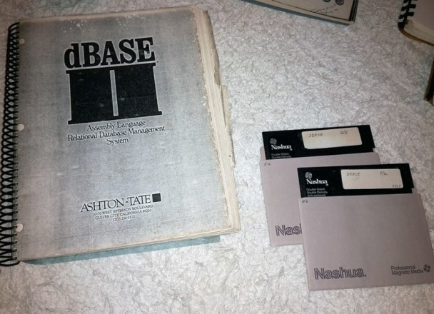 Exemplar de material impresso do dBase II, ao lado de disquetes de 5¼