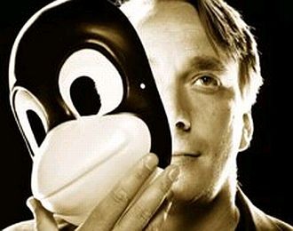 Linus Torvalds, em foto publicitária, tira uma máscara de pinguim.