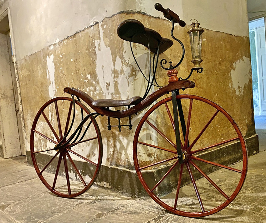 Réplica de uma bicicleta em modelo disponível em 1819, sem pedais ou corrente.