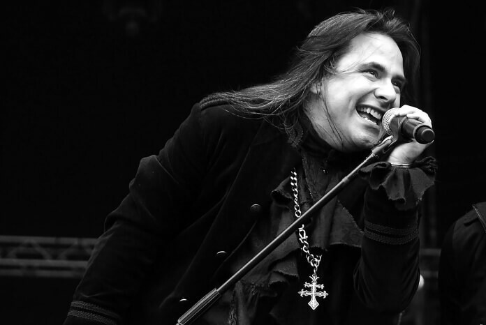 Foto em preto e branco de André Matos no palco