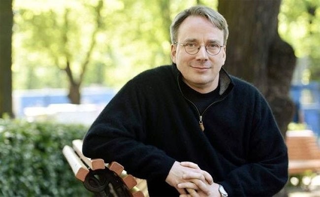 Linus Torvalds, de agasalho preto, sorri para a câmera