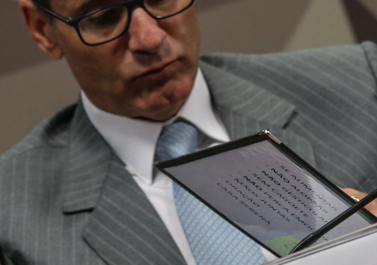 Foto de Gabriela Biló mostrando depoente, no Legislativo, com lista de instruções onde se lê: Se alimentar, não aloprar, não gesticular, sem gagoete, e outros itens.