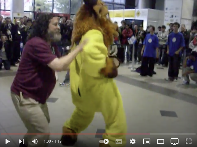 Richard Stallman e o GNU, de perfil, em momento capturado do vídeo da dança.
