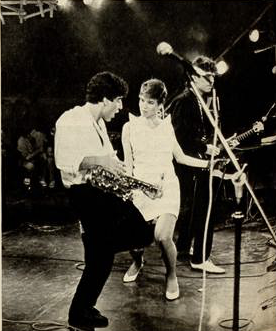 Foto em preto e branco da banda Kid Abelha no palco do evento.