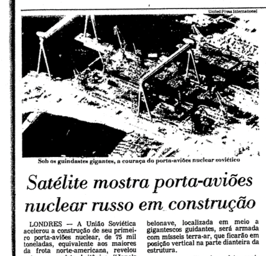 Fragmento de matéria de jornal com foto aérea de estaleiro e a manchete: Satélite mostra porta-aviões nuclear russo em construção