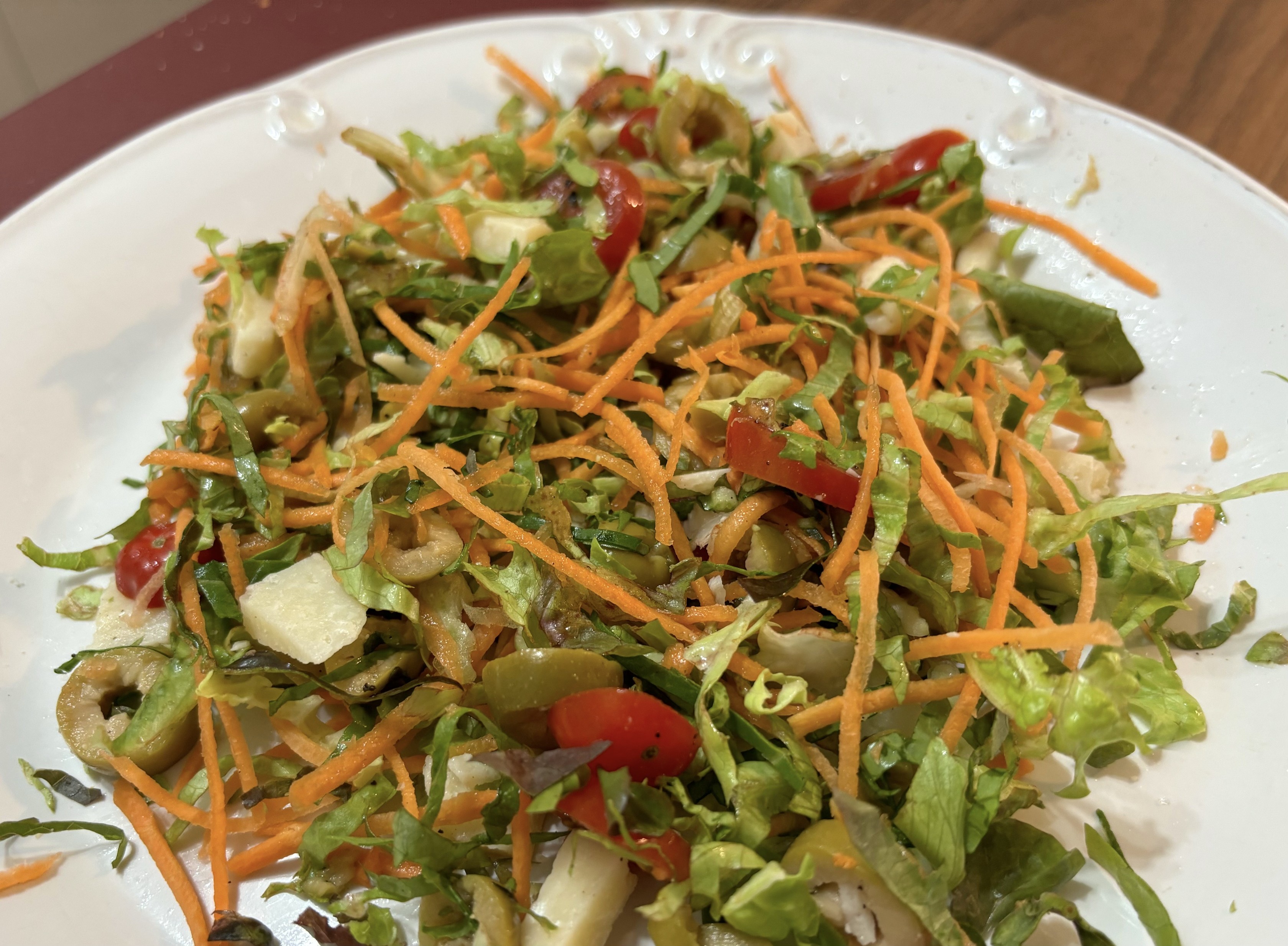 Um prato servido com uma saladinha de folhas picadas