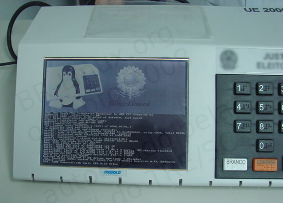 Foto da tela de boot das urnas eletrônicas com Linux em 2008, mostrando o pinguim Tux e o Brasão da República.<br>