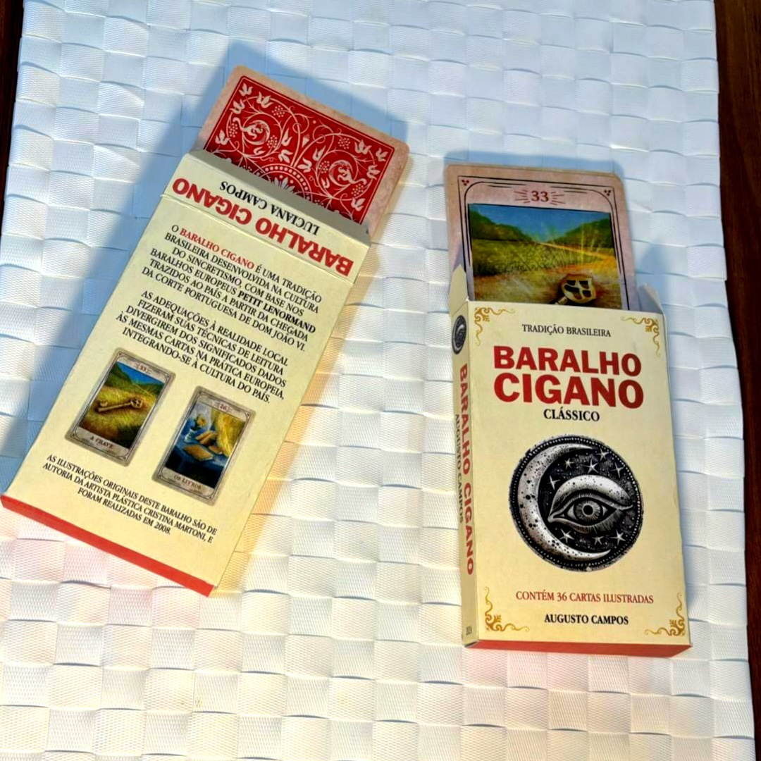 Lado a lado, duas caixas de papel contendo baralhos. A que está de frente para a câmera contém um rótulo que diz: Baralho Cigano clássico - Contém 36 cartas - Augusto Campos
