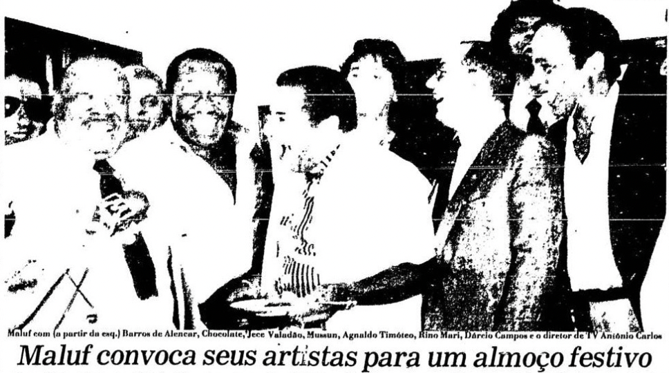 Foto pouco visível de edição antiga de jornal, mostrando o candidato e vultos de outras pessoas ao seu redor, com o título “Maluf convoca seus artistas para um almoço festivo”.