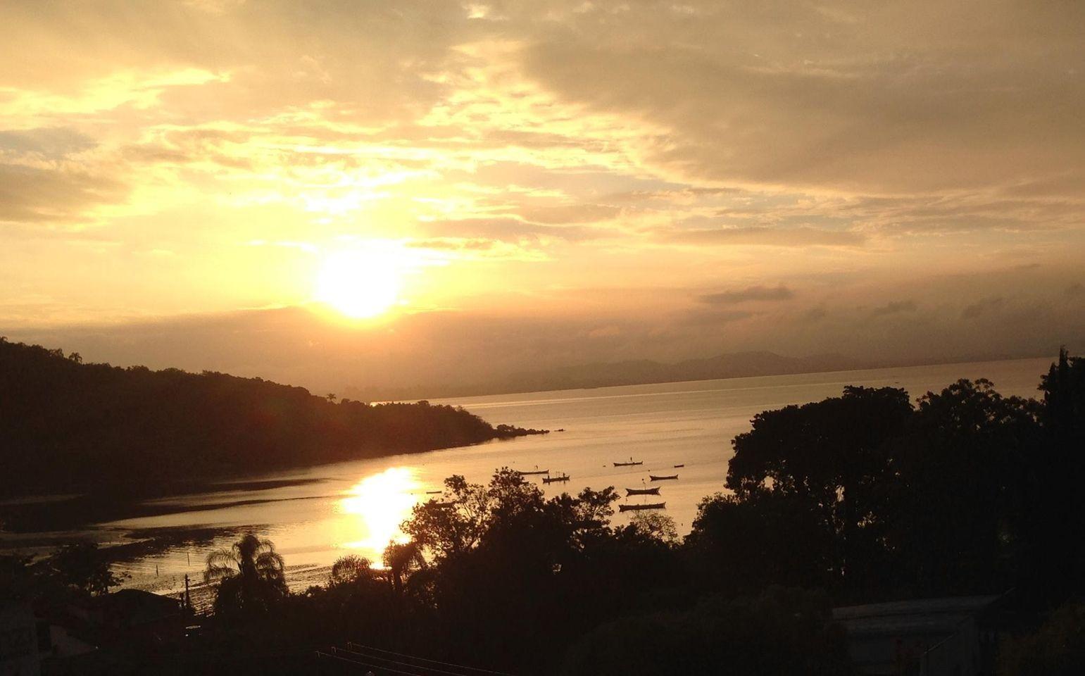 porto de pescadores artesanais, na maré baixa, sob a luz dourada de um por do sol de quase verão