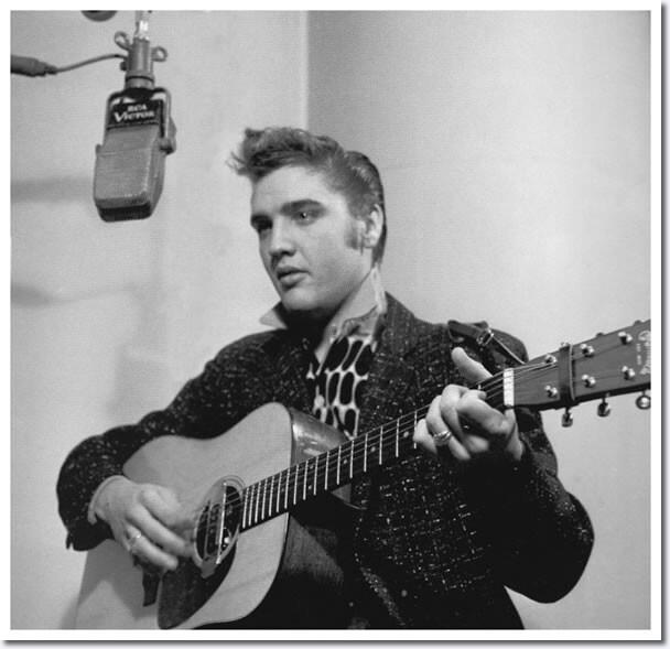 Foto em preto e branco de Elvis com seu violão em estúdio.