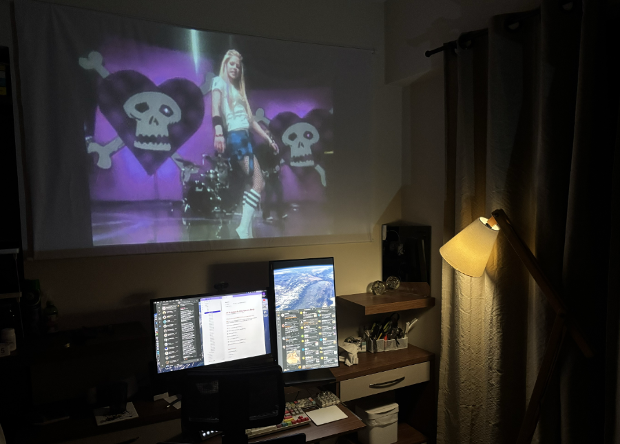 A mesma tela de projeção mostrada no post anterior, mas agora em ambiente com pouca iluminação, e o projetor ligado mostrando uma cena do clip da música Girlfriend, da Avril Lavigne