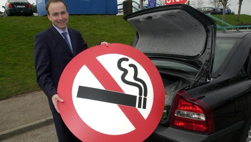 O então ministro da saúde irlandês, com a placa de Proibido Fumar que ele carregava no porta-malas de seu carro no período de campanha pela proibição.