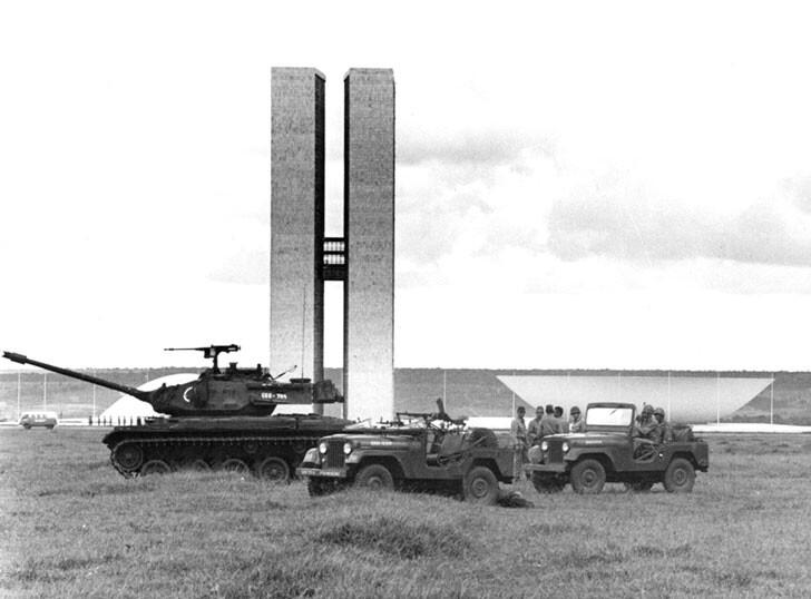 Foto em preto e branco de veículos militares em frente à sede do legislativo federal