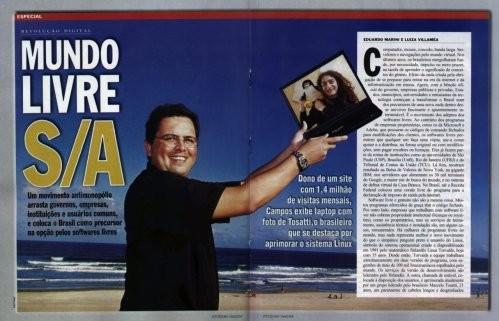 Abertura em página dupla, com foto minha segurando um laptop na praia, da matéria “Mundo Livre S/A“, na Isto É.